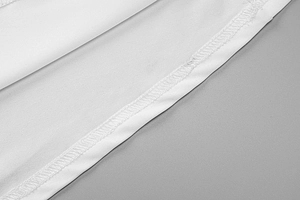 Vista macro delle cuciture di precisione e della trama del tessuto su un abito bianco