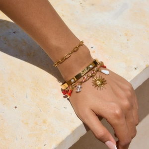 Gold-tone bracelet set with paperclip chain, rhinestone heart bangle, and coral charms