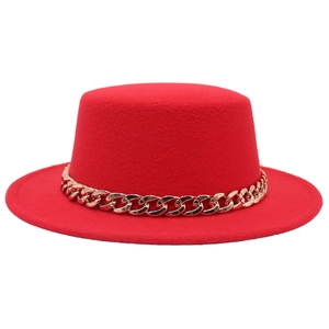 Dettaglio cappello boater in feltro rosso con grossa catena in acrilico dorato lucido