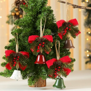 Rustic Christmas iron bells with bow and pine cones hanging on a festive tree branch