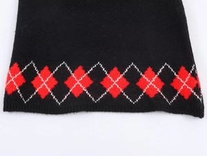 Gros plan de l'ourlet en tricot avec motif argyle rouge et blanc classique sur noir