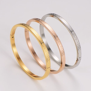 Detail of three-color greek key pattern metal bracelets in gold rose gold and silver