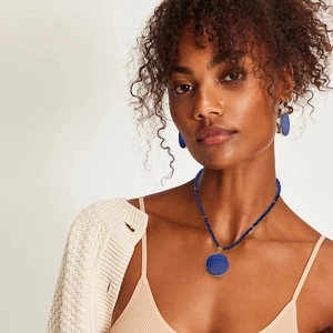 Close-up of elegant beaded lapis lazuli necklace and matching earrings on model