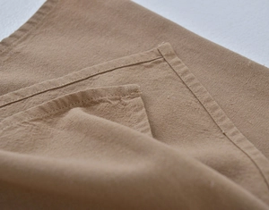 Detailed close-up of the high-quality linen texture and reinforced stitching of the apron