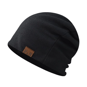 Close-up of black knitted beanie featuring a fine texture and brown leather F&S logo tag