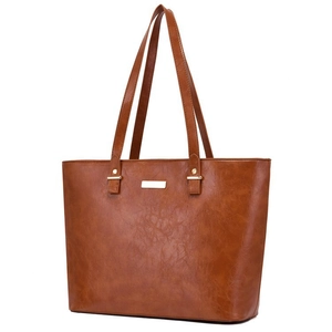 Close-up of vintage brown leather tote bag with metallic hardware and distressed texture