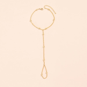 Detailed close-up of golden metal star butterfly chain ring hand harness with lobster clasp