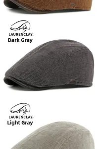 Detail view of corduroy beret hats in brown, dark grey and light grey with metal plate
