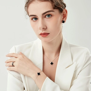 Close-up of S925 sterling silver jewelry set featuring black clover motifs and zircon rings
