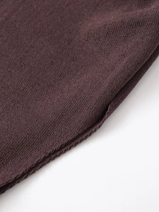 Close-up of fine dark chocolate knit fabric showing professional hem stitching details