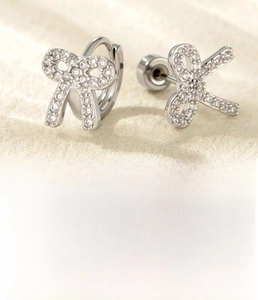Macro shot of silver bow earring set with titanium steel and cubic zirconia details