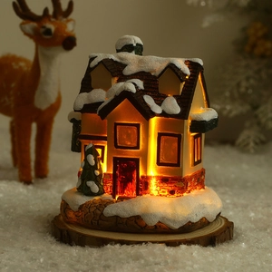 Détail de la maison de Noël lumineuse en résine avec texture neigeuse et lueur LED chaude