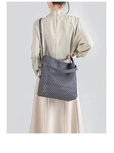 Detail of the woven texture on this dark gray PU leather tote bag with wide shoulder strap