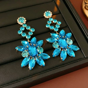 Macro de boucles d'oreilles vintage fleurs avec strass bleus et base dorée polie