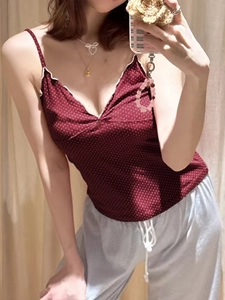 Close-up of a burgundy polka dot camisole with white ruffles and matching lounge pants