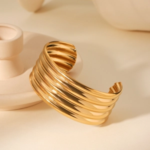 Macro shot of 18K gold plated stainless steel wide cuff bracelet with tiered stripe design