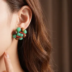 Ethnic bohemian hoop earrings featuring green beads and brown wood beads in a retro style