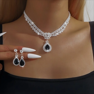 Elegant bridal jewelry set featuring a silver necklace and black drop earrings on a model