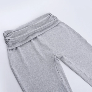Detailed close-up of grey knitted yoga pants featuring a pleated waist design and texture