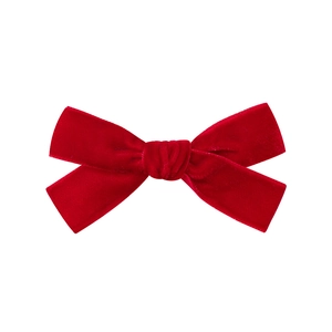 Close-up of red velvet bow hair clip showing plush texture and handmade craftsmanship