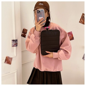 Close-up of quilted black laptop sleeve with stylish down puffer texture in a lifestyle mirror shot