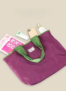 Spacious foldable shopping bag in purple and green showing large storage capacity