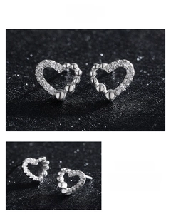 Detail of 925 sterling silver heart earrings with micro-inlaid zircon and polished beads