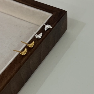 925 Sterling silver gold and silver croissant studs on wooden jewelry tray