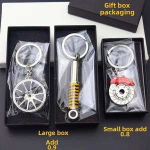 Detailed set of metallic car wheel, shock absorber, and brake disc keychains in gift boxes