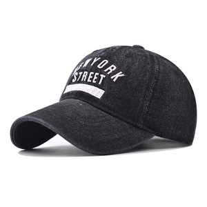 Detail of New York Street embroidery and woven label on washed denim baseball cap