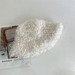 Close-up of soft white fleece fabric texture on a minimalist winter bucket hat
