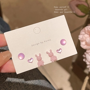 Detalle del set de pendientes de plata S925 con conejitos rosas y corazones