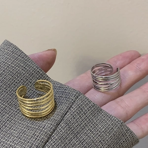 Detail of gold and silver multi-layer wire wrapped open rings on a fabric sleeve