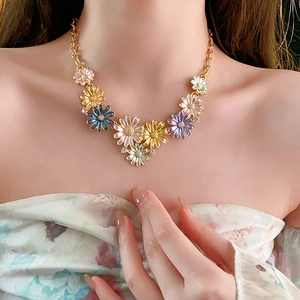 Detail of colorful flower pendant necklace with rhinestones and gold chain on model
