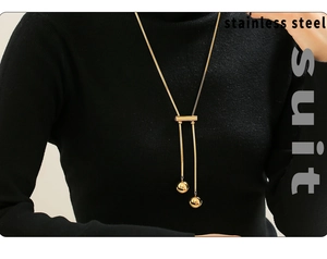 Detail of a 18K gold-plated stainless steel sweater necklace with long tassel beads on a model