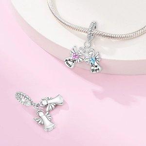 Detail of silver angel pendants with Peace and Hope engraving and colorful rhinestones