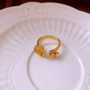 Detail of matte gold rose flower open ring with sparkling zircon in ceramic tray