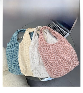 Detail of four colorful floral lace tote bags showing intricate 3D crochet patterns