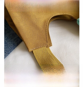 Detailed close-up of mustard yellow canvas tote showing reinforced double-stitch seams