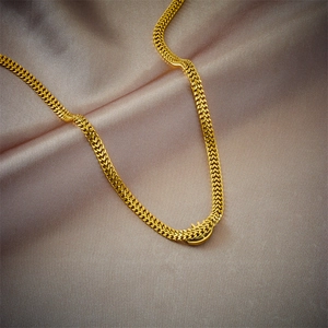Golden titanium steel chain necklace with hollow blue eye pendant on beige silk fabric