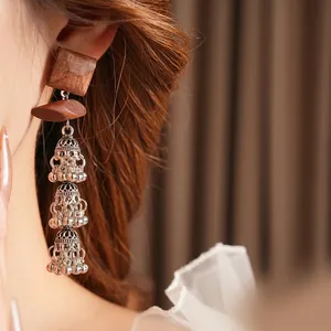 Vintage bohemian square wooden earrings with silver tassels on a female model