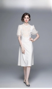 Détail d'une élégante robe blanche avec empiècement en dentelle et perles exquises