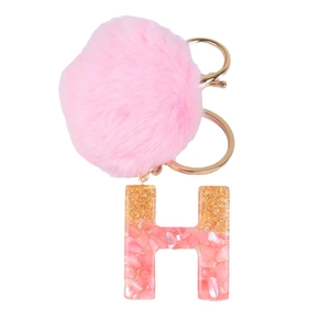 Pink fluffy pom pom keychain with gold foil resin letter H pendant on a white background