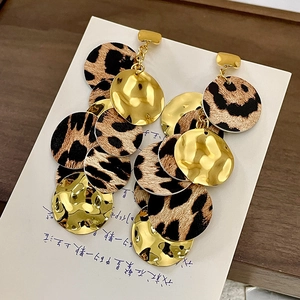 Détails de boucles d'oreilles vintage avec imprimé léopard et disques dorés martelés