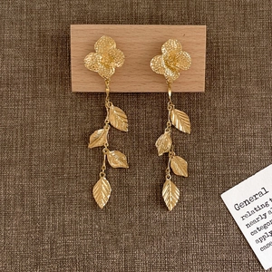 Boucles d'oreilles pendantes fleurs et feuilles dorées avec texture naturelle