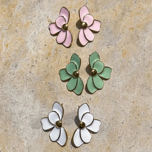 Detailed flat lay of flower earrings in pink, green and white with gold borders