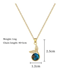 Detail of mermaid tail pendant necklace featuring blue star stone and zircon stones