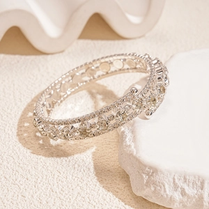 Macro detail of silver-toned zircon bracelet featuring multi-row hollow pave settings
