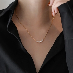 Minimalist titanium steel necklace featuring eight small pearls on a thin gold chain