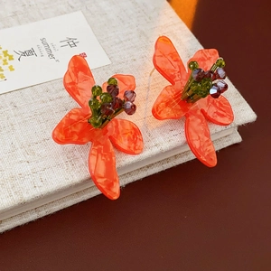 Detailed macro view of orange floral vintage earrings with green and purple crystal beads